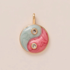 Macro detail of yin yang flower pendant with pink and green enamel and zircon stones