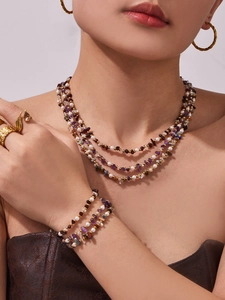 Detail of layered freshwater pearl and natural stone necklace set on model neck