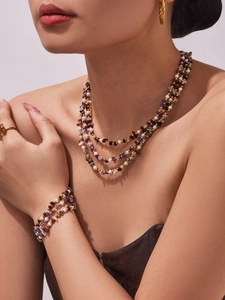 Detailed view of triple-layered natural stone and pearl necklace with golden chain link