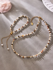 Detail of colorful natural stone and pearl beaded necklace with gold stainless steel chain