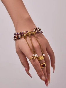 Detail of bohemian gold-plated ring and bracelet set with natural stones and pearls