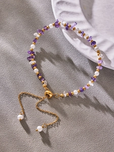 Macro detail of natural pearl and purple gemstone adjustable bracelet with golden chain