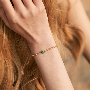 Minimalist gold beaded Evil Eye bracelet with green enamel protection charm for women