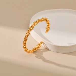 French style chunky gold chain open cuff bracelet on a minimalist porcelain tray
