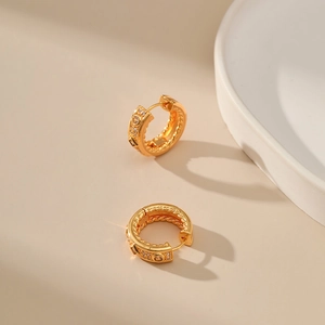 Nahaufnahme der 18K vergoldeten Creolen mit gedrehter Textur und Zirkonia-Inlay