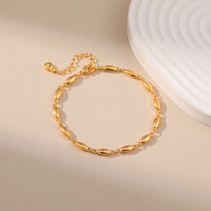 Close-up of golden oval bead link chain with adjustable lobster clasp and polished finish