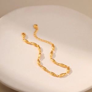 Detailed view of adjustable gold-tone bracelet with oval links and lobster clasp