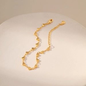 Detail of 18K gold plated heart link bracelet featuring lobster clasp and extension chain