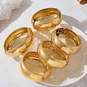 Five-piece set of gold textured wide open bangles with diverse metal relief patterns