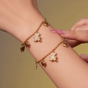 Golden bead chain bracelets featuring crystal bear, heart, and butterfly charms for women
