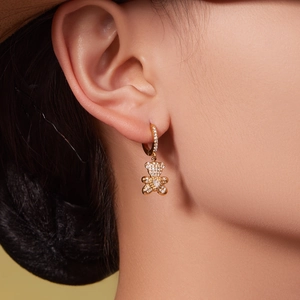 Elegant gold bear hoop earrings with sparkling zircon stones worn by a female model