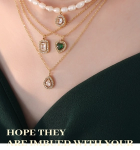 Détail du collier multicouche doré avec perles d'eau douce et pendentifs pierres vertes