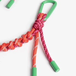 Close-up of handmade woven orange and pink rope keychain with green metal carabiner