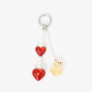 Detail of keychain featuring white pearls, red heart charms, and a yellow duck pendant