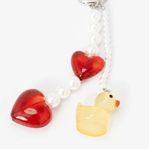 Detail of beaded keychain with red heart charms, white pearls, and a yellow duck pendant