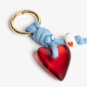 Macro view of handmade red glass heart pendant with woven rope and beaded keychain