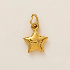 Détail d'un pendentif étoile dorée avec gravure Lucky et anneau de suspension métal