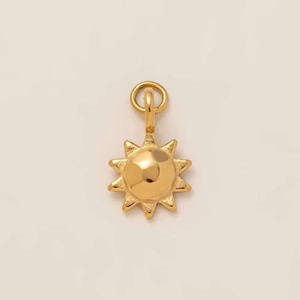 Détail d'un pendentif soleil doré avec rayons radiants et centre sphérique poli