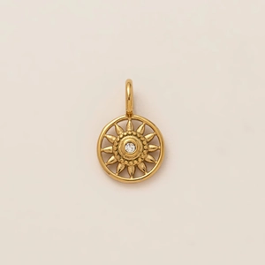 Gros plan du pendentif soleil doré avec zircon central et détails perlés sophistiqués