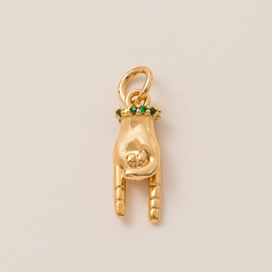 Detailed view of a gold-plated rock hand gesture pendant with green emerald accents