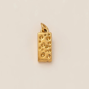 Détail macro d'un pendentif rectangulaire plaqué or avec texture alvéolée et anneau clos