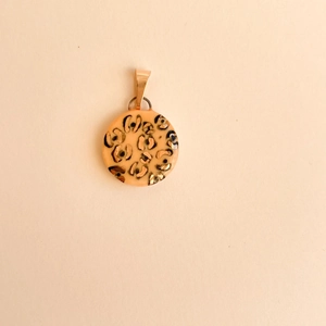 Close-up of leopard print round pendant with gold bail and glossy resin finish