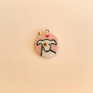 Detail of 18K gold-plated round heart charm featuring a hand-painted white puppy and red heart