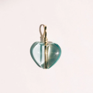 Macro-opname van een lichtblauwe hartvormige transparante hanger met gouden draad
