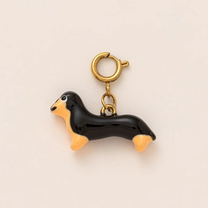 Detail of dachshund dog charm with glossy black and gold enamel finish and clasp