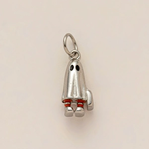 Détail macro d'un pendentif fantôme plaqué or 18K avec finition argent et bottes rouges