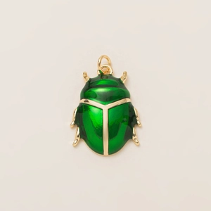 Dettaglio di un ciondolo a scarabeo verde con placcatura in oro 18K e smalto