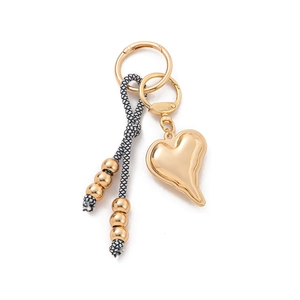 Macro detail of a high-shine golden heart charm keychain with fluid melting design