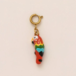 Detail of colorful parrot pendant in gold finish with vibrant red enamel and spring clasp