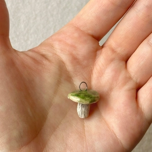 Detailaufnahme eines Miniatur Pilzanhängers mit grüner Kappe und weißem Stiel