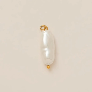 Detailed close-up of a white baroque pearl pendant with 18K gold-plated metal bead and ring