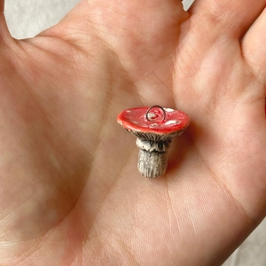 Mini-Pilzanhänger in Rot mit 18K Goldring, in der Hand zur Größendarstellung gezeigt