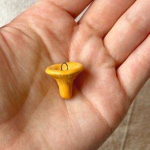 Detaillierte Ansicht eines kleinen gelben Pilzanhängers in der Hand für die Miniaturgröße