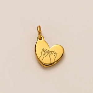 Detail showing an 18k gold heart pendant with engraved pinky promise hand gesture
