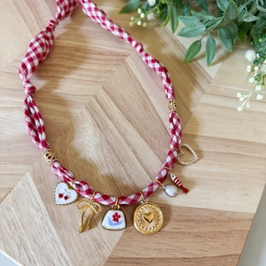 Dettaglio della collana in tessuto floreale con ciondoli a cuore e perle su legno
