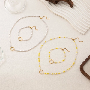 Détail d'un ensemble collier et bracelet en perles avec finition dorée et fermoirs