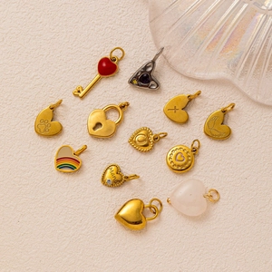 Golden heart charms with enamel designs and 18k gold plating on textured surface