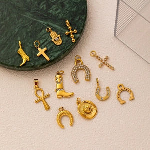 Collection of vintage gold charms with cross, cowboy boot, and horseshoe with zircons