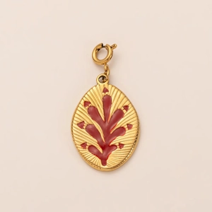 Detail of gold oval pendant with red enamel coral texture and polished spring clasp