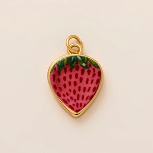 Detail of strawberry charm pendant with red enamel and 18K gold plated frame