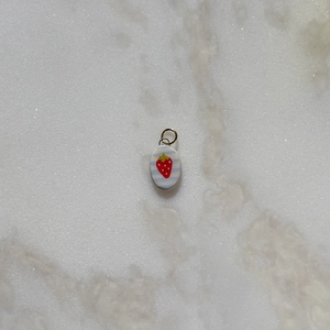 Detail view of oval strawberry pendant with blue stripes and silver bail