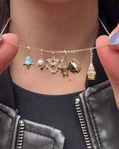 Dettaglio della catena placcata oro 14K con pendenti vintage colorati indossata dal modello