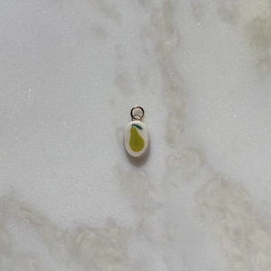 Detailed view of an oval pear pendant with minimalist fruit illustration and golden ring