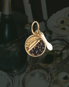Dettaglio del ciondolo scatola di caviale placcato oro 14K con pietre nere e cucchiaio