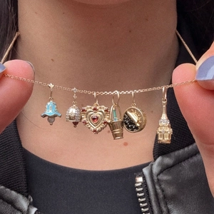 Collana placcata oro con sei ciondoli assortiti tra cui smalto blu e cuore di rubino