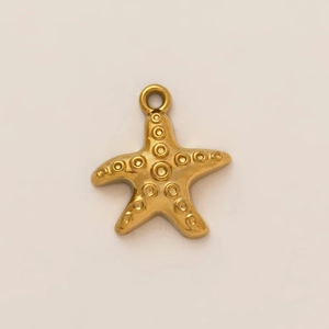 Dettaglio macro di un ciondolo a stella marina placcato oro 18K con texture a rilievo e anello